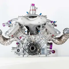Silnik V8 z turbodoładowaniem, z widocznymi elementami turbo compound, błyszczący metal, fioletowe akcenty.