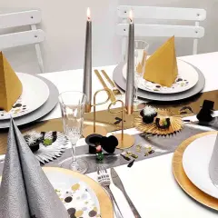 Festlich gedeckter Tisch mit Kerzen, Gläsern und Servietten in Gold und Silber. Eine tolle Silvester Idee für eine glamouröse Feier.
