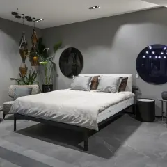 Nowoczesna sypialnia z kinkietami, łóżkiem i designerskimi dodatkami.