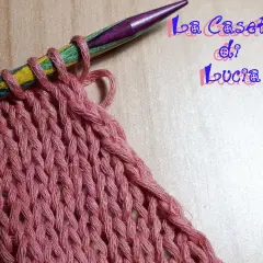 Uncinetto su ferri colorati, un lavoro a maglia rosa che ricorda un baktus.