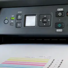 Drukarka Canon z wyświetlaczem i wychodzącym z niej wydrukiem.