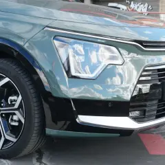 Detaljer från en kia niro hybrid test: framhjul, strålkastare och grill.