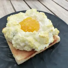 Un œuf nuage aérien sur une tranche de pain grillé, parfait pour une recette légère et gourmande.