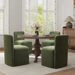 Four green chairs with plush, straight backs surround a round wooden table, showcasing modern types of chair backs.