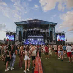 Folla in attesa davanti al palco del Mallorca Live Festival, con schermi giganti che proiettano l'artista.