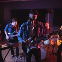 Zespół rockowy grający na gitarach, klawiszach i perkusji w studiu nagraniowym.