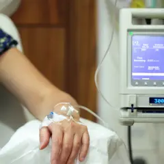 Pacjent otrzymuje kroplówkę, która może być lekiem na raka. Aparatura medyczna monitoruje przepływ płynu.