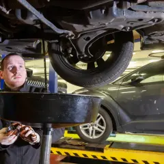Mechanik wymienia olej w samochodzie. Zastanawiasz się, ile kosztuje serwis olejowo filtrowy?