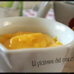 Crema pasticcera ricetta della nonna, densa e dorata, in una ciotola bianca. Un piacere per gli occhi e per il palato.