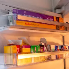 A collection of 35mm film rolls, including Kodak Portra 400 and Kodak Professional, stored in a refrigerator. These films are perfect for achieving that best 35mm film for vintage look.