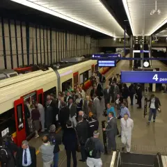 Ludzie wsiadają do pociągu na peronie 4. To część infrastruktury łączącej lotniska w Warszawie z centrum miasta.