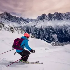 Narciarz zjeżdża po ośnieżonym stoku w Vallee Blanche, podziwiając majestatyczne Alpy.