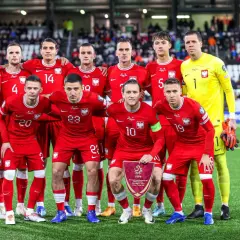 Piłkarze reprezentacji Polski w czerwonych strojach, gotowi do gry. Drużyna, która jak polska wyspy owcze, walczy o zwycięstwo.