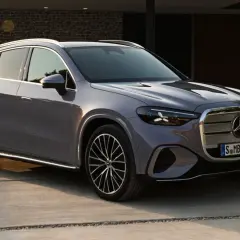 Un elegante GLC eléctrico 2026 gris metálico, con diseño moderno y llantas deportivas, estacionado en una entrada de concreto.