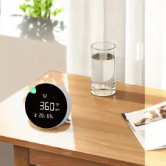 Monitor de calidad del aire muestra 360 ppm, indicando niveles de CO2 saludables en un ambiente hogareño.