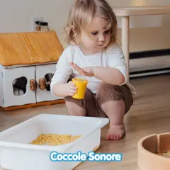 Bambina di 2 anni gioca con pasta in un vassoio, un'attività sensoriale divertente.