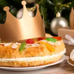 Un gâteau pour accompagner le champagne, décoré de fruits confits et d'une couronne dorée, prêt pour une fête royale.
