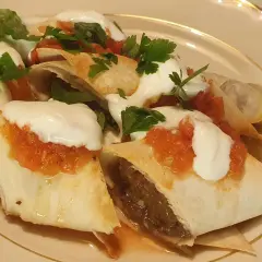 Beyti kebab med yoghurt, tomatsås och persilja. En läcker rätt som ser ut att smaka fantastiskt.