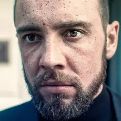 Twarz mężczyzny z zarostem i śladami na skórze, jakby przeżył trudne chwile. Może to scena z filmu "Walden jak zostałem gangsterem".