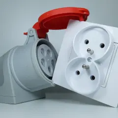 Szara wtyczka przemysłowa i biała podwójna gniazdko elektryczne. Zastanawiasz się, ile kosztuje założenie siły w domu?