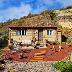Acogedora casa rural de piedra, rodeada de plantas y con un camino de madera que lleva a la entrada. Un lugar perfecto para disfrutar de la tranquilidad de el escobonal.