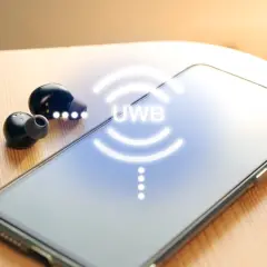 Auriculares inalámbricos y un smartphone con el símbolo UWB que es una tecnología de comunicación.