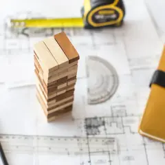 Ritningar, måttband och träklossar som symboliserar planering för att bygga garage.