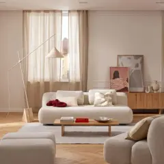 Helle Leinen-Gardinen schaffen eine warme Atmosphäre. Tolle Gardinen Ideen für ein gemütliches Wohnzimmer mit beigen Sofas und Holzboden.