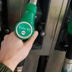 Ręka wybiera dystrybutor z paliwem Euro 95 E10. Czy to paliwo dla hybrydy?