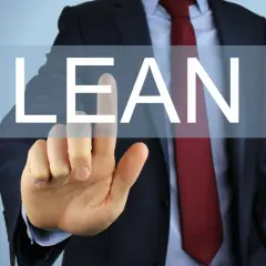 Biznesmen w garniturze dotyka ekranu z napisem "LEAN".
