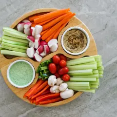 Bunter Gemüseteller mit Hummus und Dip – perfekt für einen 1000 kcal am Tag Essensplan. Karotten, Gurken, Radieschen, Paprika, Tomaten, Sellerie und Pilze.