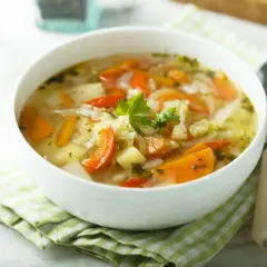 Aromaticzny kapuśniak ze słodkiej kapusty z marchewką i ziemniakami, udekorowany natką pietruszki. Idealny na chłodne dni.