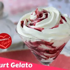 Coppa di gelato con yogurt greco e variegatura ai frutti di bosco, guarnita con panna montata.