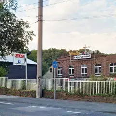 Ziegelgebäude mit Schildern "Nivella-chromolit Lagerverkauf" und "SILAG Handel AG Lagerverkauf" in Piepersberg, Solingen.