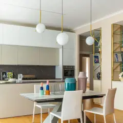 Cucina moderna con isola e zona pranzo. Parete con libreria dorata e affresco marino, un'ispirazione per idee pareti soggiorno moderne.