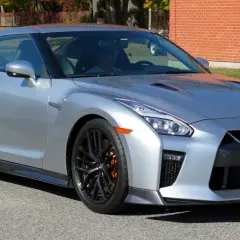 Srebrny Nissan GTR z pomarańczowymi zaciskami hamulcowymi, gotowy do jazdy.