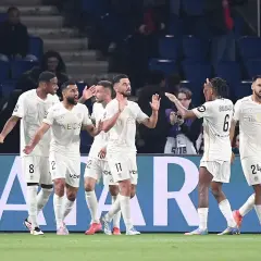 Piłkarze OGC Nice świętują bramkę przeciwko Stade de Reims. Drużyna w białych strojach z numerami 8, 2, 11, 6 i 24 cieszy się z sukcesu.