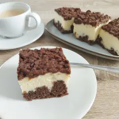 Sernik królewski stary przepis. Puszysty sernik z czekoladową kruszonką i kawą na drewnianym blacie.