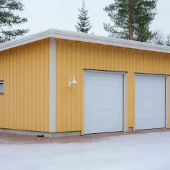 Gult garage med tre vita garageportar, redo att måla om.