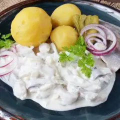 Matjesfilets in cremiger Soße mit Pellkartoffeln, Gurken und Zwiebelringen. Ein Klassiker, der zeigt, wie gut Matjes einlegen gelingt.