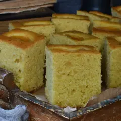 Kawałki puszystego ciasta, które wyglądają jak z przepisu na ciasto dziad babci Ewy, ułożone w drewnianej skrzynce.