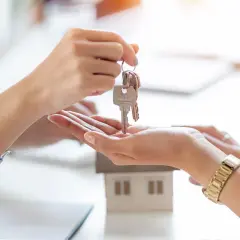 Manos intercambian llaves de una casa modelo. Un nuevo comienzo, que significa cru, se materializa en este momento.