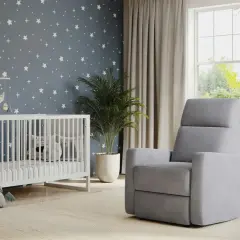 A modern nursery idea with a starry wallpaper, white crib, plush toys, and a comfy grey recliner.