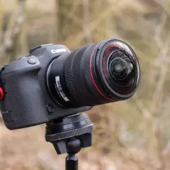 Obiektyw Canon z soczewką przypominającą rybie oczy, zamontowany na statywie, gotowy do uchwycenia świata w szerokim kadrze.