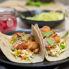 Två läckra fish tacos med krispig fisk, kål, rödlök och en krämig sås. Ett perfekt recept för en snabb och god middag.