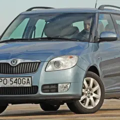 Niebieska Skoda Fabia Combi, idealne jakie auto rodzinne, z kierowcą za kierownicą, na tle jasnego nieba.