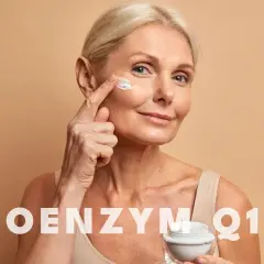 Kobieta aplikuje krem z koenzymem Q10 na skórę wokół oczu. Koenzym Q10 na co? Na odmłodzenie i regenerację.