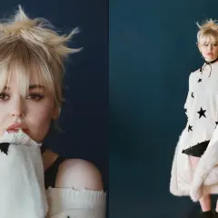 Emily Alyn Lind med rufsigt blont hår, bär en stickad tröja med stjärnor och en pälskappa.