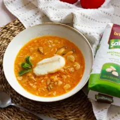Sopa de pescado con arroz sencilla, con trozos de pescado, mejillones y arroz redondo Sabroz, decorada con menta.