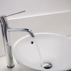 Grifo moderno y lavabo blanco. ¿Buscas el precio reforma baño 4 m2?